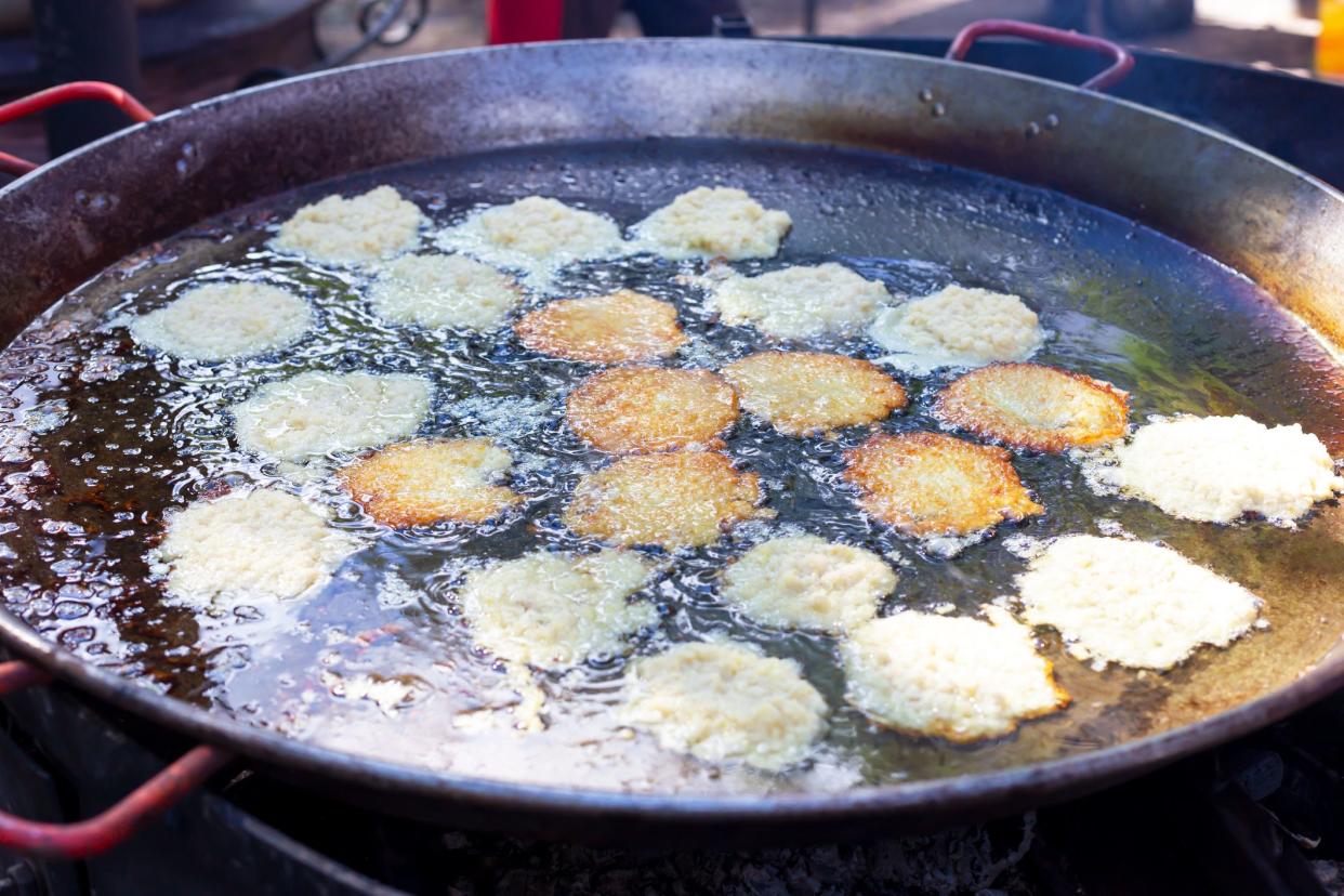 The potato fritters are fried in a large frying pan. Very tasty and appetizing. Top view