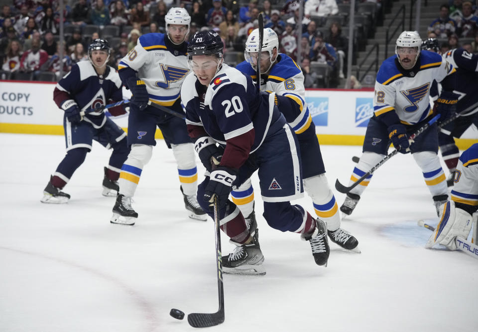 Colorado Avalanche center Ross Colton, front, passes the puck as St. Louis Blues defenseman Marco Scandella pursues during the third period of an NHL hockey game Saturday, Nov. 11, 2023, in Denver. (AP Photo/David Zalubowski)