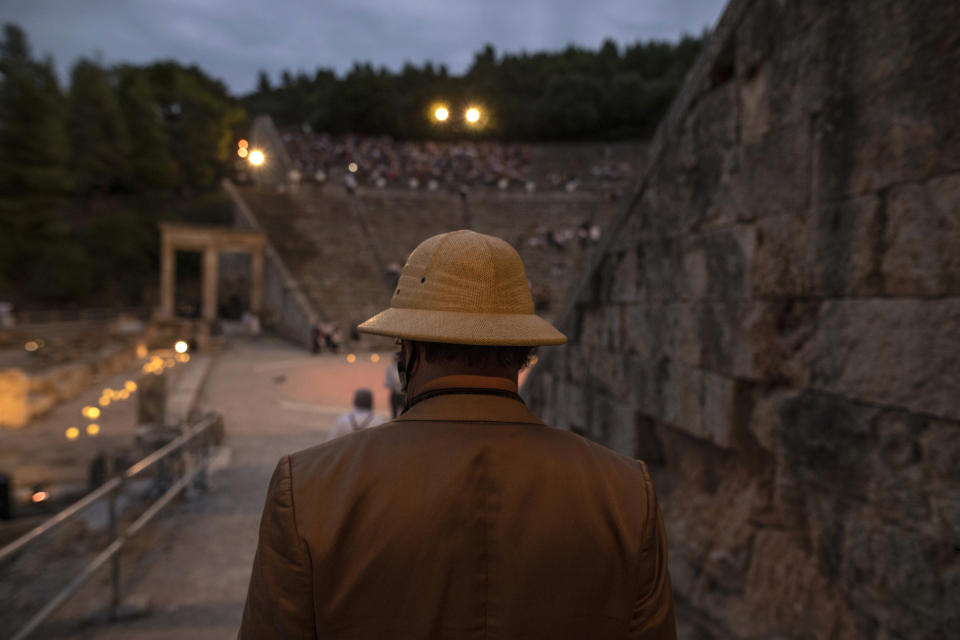 A man enters the ancient theater of Epidaurus, Greece, on Friday, July 17, 2020, to listen a solo concert by Greek violinist Leonidas Kavakos. Live concerts and events have been mostly canceled in Greece this summer due to pandemic concerns. But the Culture Ministry allowed the ancient theaters of Epidaurus in southern Greece and Herodes Atticus in Athens to host performances under strict safety guidelines.(AP Photo/Petros Giannakouris)