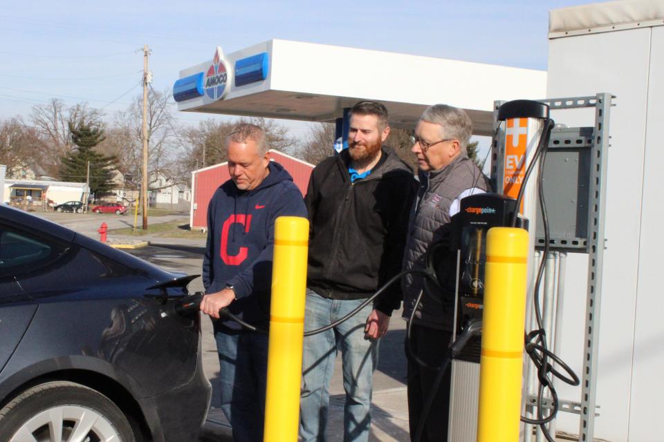 Firelands Co-Op member Dan Osborne of Willard (left) takes advantage of the new EV charger at New London's Amoco/Gas Depot. Pictured with him are Gas Depot owner Creighton Ruggles (center) and Firelands Electric Cooperative General Manager Dan McNaull.