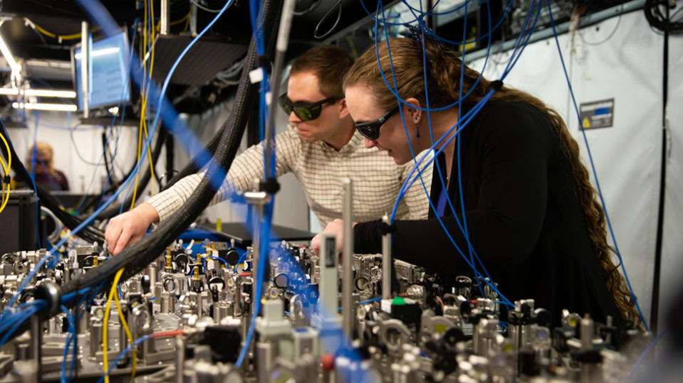 Quantinuum scientists making adjustments to a beam line array used to deliver laser pulses in H-Series quantum computers. 