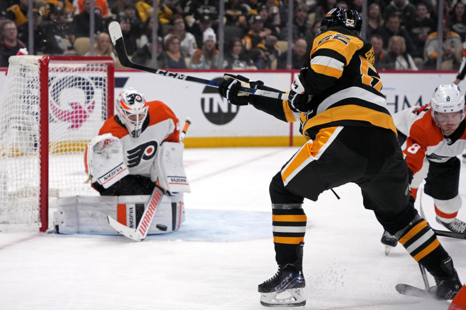 Pittsburgh Penguins' Emil Bemstrom (52) gets a shot past Philadelphia Flyers goaltender Cal Petersen (40) for a goal during the second period of an NHL hockey game in Pittsburgh, Sunday, Feb. 25, 2024. (AP Photo/Gene J. Puskar)