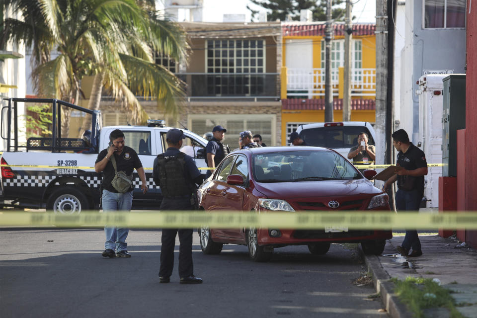 Police and forensic personnel work the crime scene where journalist Marcos Miranda was kidnapped, in Boca del Rio, Veracruz state, Mexico, Wednesday, June 12, 2019. Miranda was abducted this morning from his home by armed men, according to the Network of Veracruz Journalists. (AP Photo/Felix Marquez)