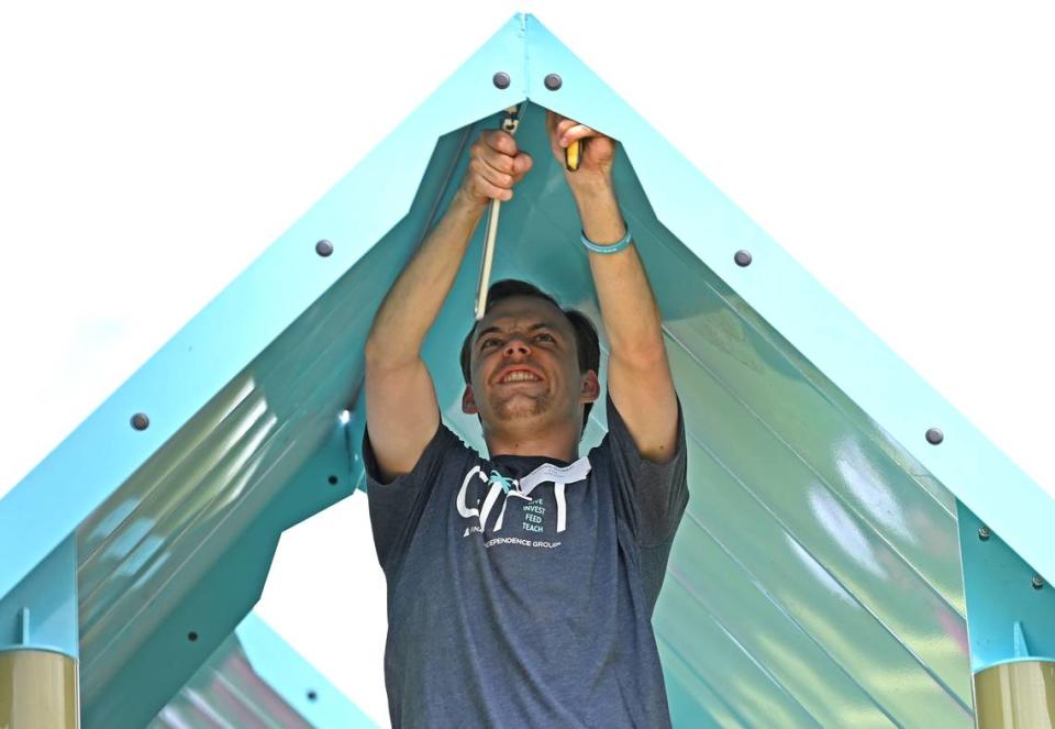 William Dugger an employee with Financial Independence Group tightens bolts on the roofing of a piece of playground equipment on Friday, April 19, 2024. Dugger and his co-workers joined employees from other local companies for the 19th Charlotte Playground Build at Westerly Hills Academy. The playground build is presented by United Way of Greater Charlotte that brings together companies across the community to build a new playground for a local Charlotte-Mecklenburg elementary school.