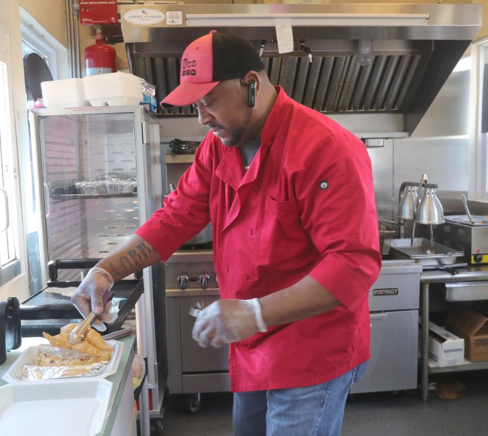A'Delbert Cobbin, owner of Big Dzz House BBQ, prepares a chicken and waffle sandwich on Thursday, May 12, 2022 in Tallmadge.