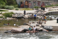 People cool off in the water at the confluence of the South Platte River and Cherry Creek in Denver, Wednesday June 16, 2021. A heat wave continues to hover over the western U.S., pushing the temperature to 99 degrees in Denver. (AP Photo/Brittany Peterson)