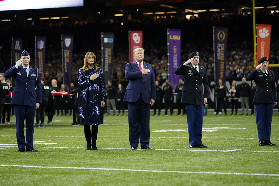 President Donald Trump, center, and first lady Melania Trump attend the NCAA College Football Playoff national championship game Monday, Jan. 13, 2020, in New Orleans. (AP Photo/David J. Phillip)