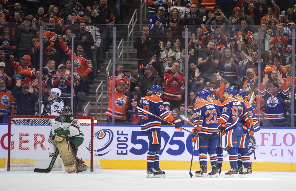 Edmonton Oilers players, right, celebrate a goal against the Minnesota Wild during first-period NHL hockey game action in Edmonton, Alberta, Friday, Dec. 9, 2022. (Jason Franson/The Canadian Press via AP)