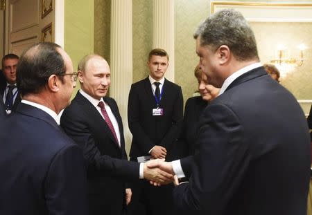 Russia's President Vladimir Putin (2nd L) shakes hands with his Ukrainian counterpart Petro Poroshenko, with France's President Francois Hollande (L) and Germany's Chancellor Angela Merkel standing nearby, as they take part in peace talks on resolving the Ukrainian crisis in Minsk, February 11, 2015. REUTERS/BelTa/Pool