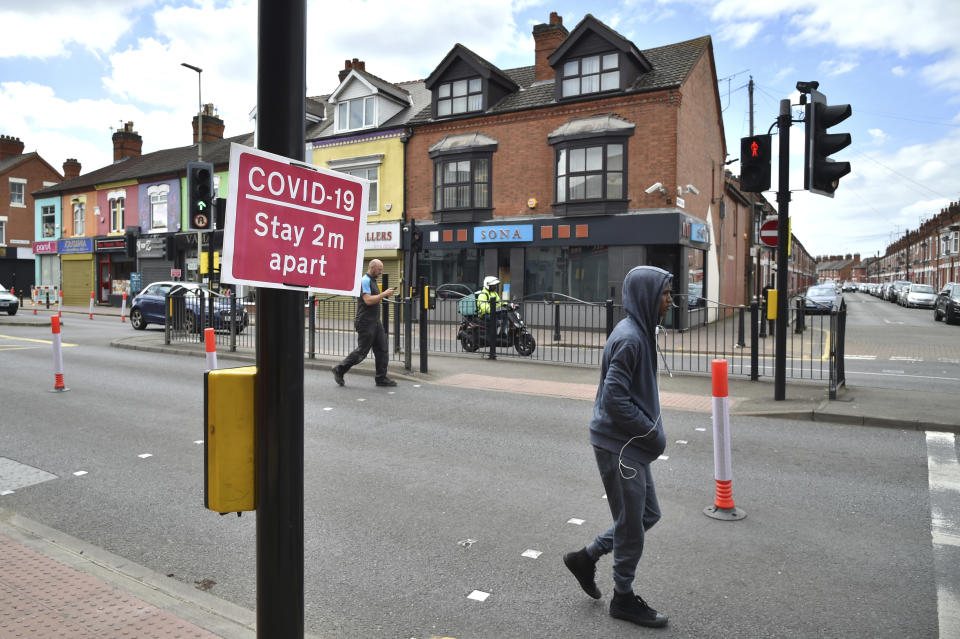 People walk in Melton Road also known as the Golden Mile in Leicester, England, Tuesday June 30, 2020. The British government has reimposed lockdown restrictions in the English city of Leicester after a spike in coronavirus infections, including the closure of shops that don't sell essential goods and schools. (AP Photo/Rui Vieira)