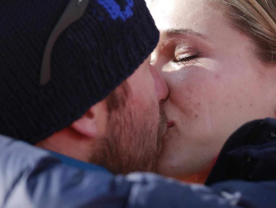 Morgan Miller kisses her husband, United States' Bode Miller after he took part in the flower ceremony for the men's super-G for his joint bronze medal at the Sochi 2014 Winter Olympics, Sunday, Feb. 16, 2014, in Krasnaya Polyana, Russia. (AP Photo/Gero Breloer)