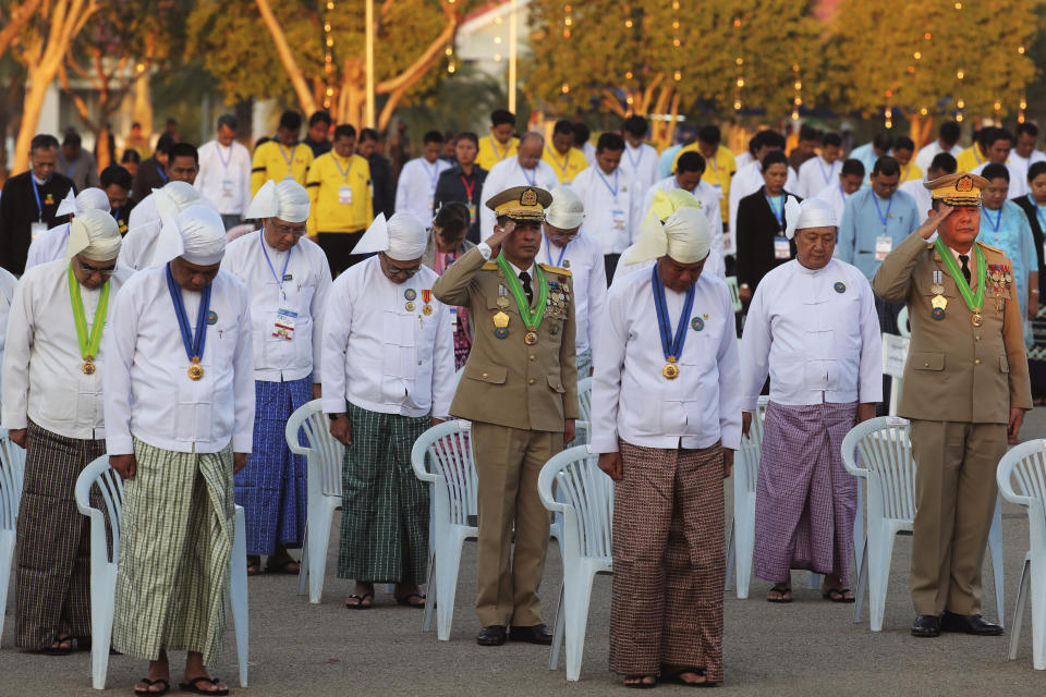 Myanmar government officials salute at their national flag during a ceremony marking Myanmar's 76th anniversary of Independence Day in Naypyitaw, Myanmar, Thursday, Jan. 4, 2024. (AP Photo/Aung Shine Oo)