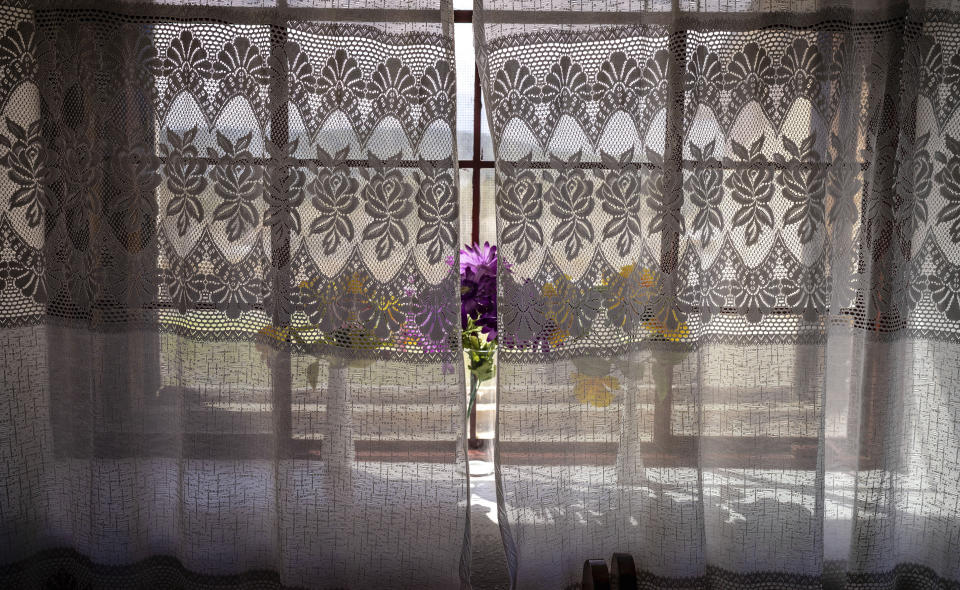 Silk flowers in vases adorn a windowsill of the San Antonio Church in Cordova, New Mexico, Friday, April 14, 2023. Preserved mostly in devotions, particularly in humble 'moradas' – as the brotherhoods' chapels are called – built of mud and straw in rural communities across the northern reaches of the state, New Mexican Spanish is different from all other varieties of the language. (AP Photo/Roberto E. Rosales)