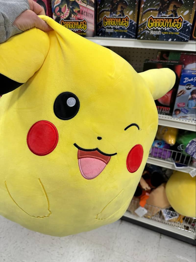 Someone holding a giant pikachu stuffed toy.