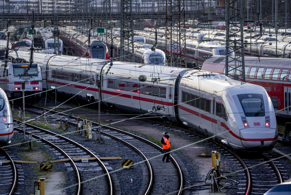 A Deutsche Bahn employee walks past ICE trains that are parked near the central train station in Frankfurt, Germany, Monday, March 27, 2023. Germany faces a nationwide public transport strike on Monday. (AP Photo/Michael Probst)