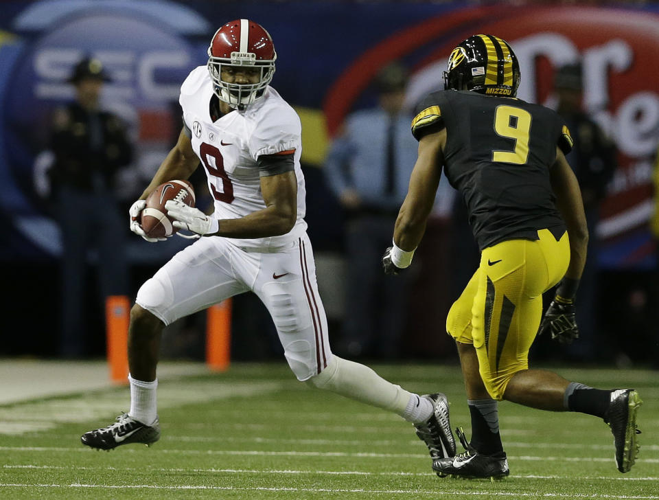 Amari Cooper, receptor de la Universidad de Alabama, trata de eludir a Braylon Webb, safety de Missouri, durnate el partido del sábado 6 de diciembre de 2014 (AP Foto/Jamie Martin)