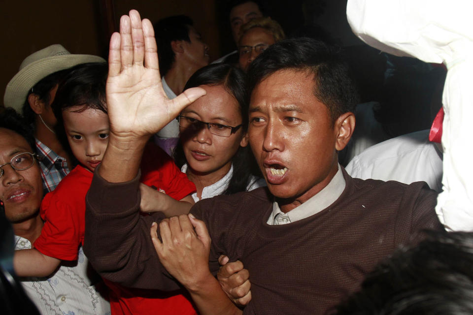 FILE - Kyaw Min Yu, a pro-democracy activist talks to journalists as he arrives at Yangon airport welcomed by his wife Nilar Thein, background, also an activist and his daughter after being released from a prison on Jan. 13, 2012, in Yangon. Myanmar has carried out its first executions in nearly 50 years. Kyaw Min Yu, a 53-year-old democracy activist better known as Ko Jimmy, was executed for violating the counterterrorism law. (AP Photo/File)