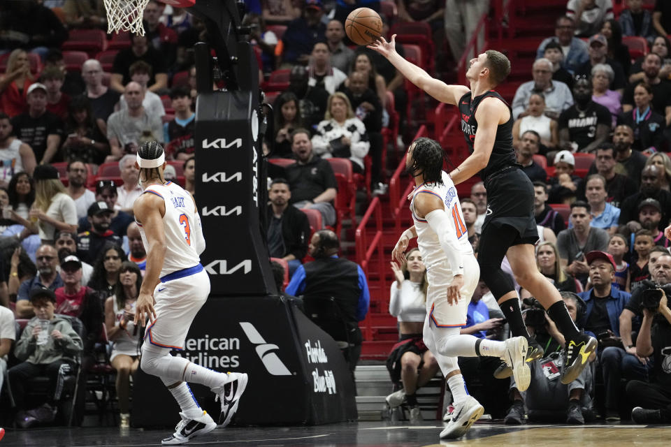 Miami Heat forward Nikola Jovic, right, shoots past New York Knicks guard Jalen Brunson (11) during the first half of an NBA basketball game, Tuesday, April 2, 2024, in Miami. (AP Photo/Lynne Sladky)