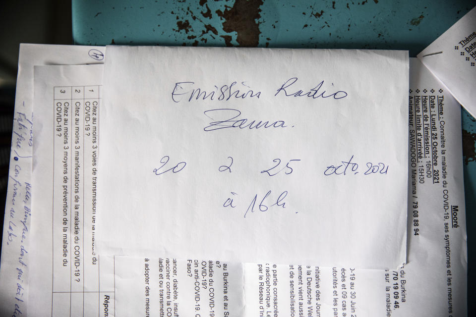 Mariama Sawadogo's show scripts on COVID-19 are set out on a table at Zama Radio, in Kaya, Burkina Faso, Monday, Oct. 25, 2021. Many guests and listeners in Burkina Faso call her "aunty" as she gently guides them to the right answers and awards prizes such as soap and washing buckets. In the West African country of Burkina Faso, many feel the government has let them down during the pandemic. Tests, vaccines and messaging often miss many residents, despite a $200 million budget for virus-response efforts. In a region where women are responsible for family work and community relationships, they’ve stepped up to fill in gaps. (AP Photo/Sophie Garcia)