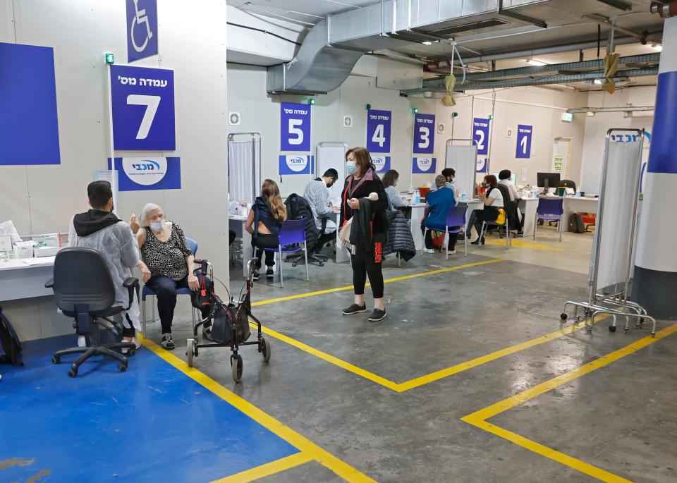 Health workers of the Maccabi Health vaccination centre administer doses of the Pfizer-BioNtech COVID-19 coronavirus vaccine inside the parking lot of the Givatayim mall in Israel's Mediterranean coastal city of Tel Aviv on January 26, 2021. (Jack Guez/AFP via Getty Images)