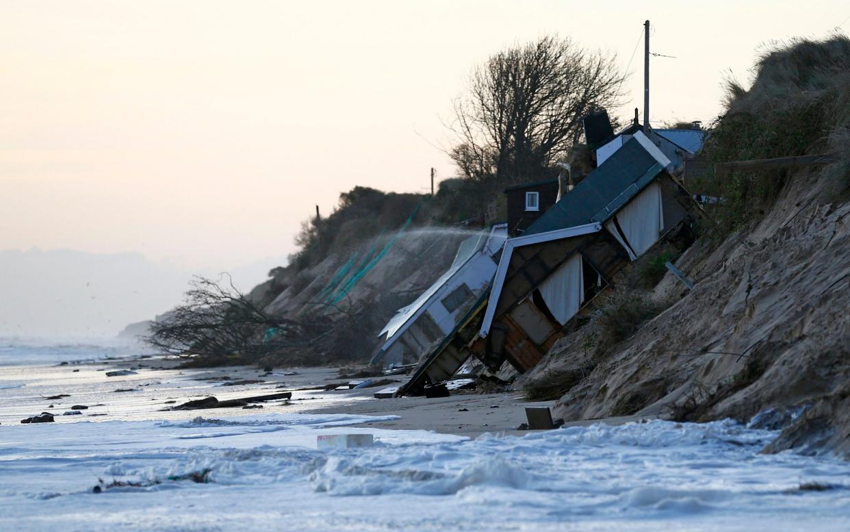 Collapsed houses on the beach after a storm surge in Hemsby, Norfolk, in 2013 - Darren Staples/Reuters