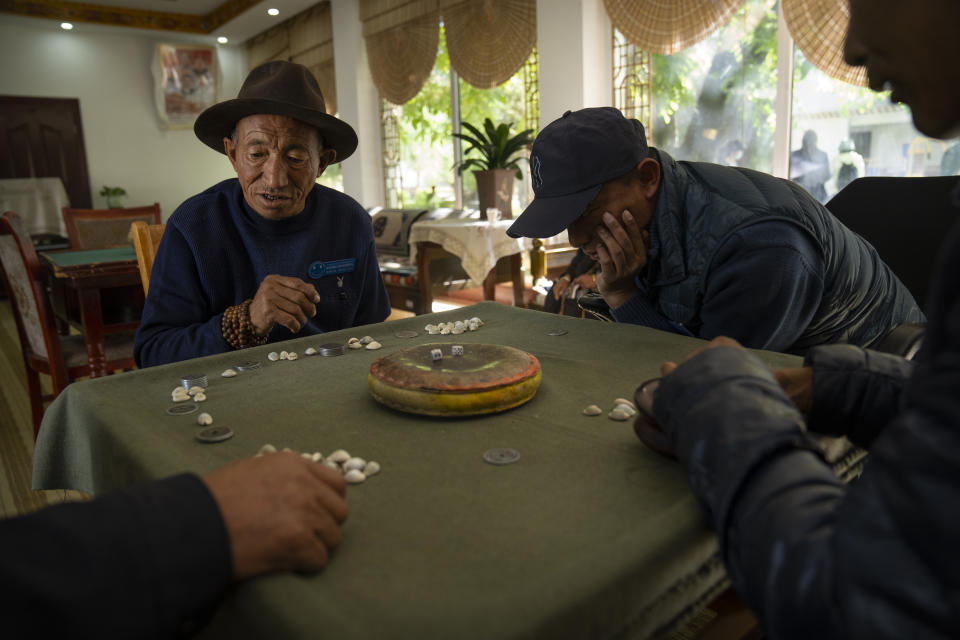 Men play a dice game at the Social Welfare Center of Chengguan District in Lhasa in western China's Tibet Autonomous Region, as seen during a rare government-led tour of the region for foreign journalists, Thursday, June 3, 2021. Long defined by its Buddhist culture, Tibet is facing a push for assimilation and political orthodoxy under China's ruling Communist Party. (AP Photo/Mark Schiefelbein)