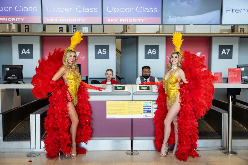 Showgirls at the check in desk at Manchester airport ahead of Flight VS85 taking off