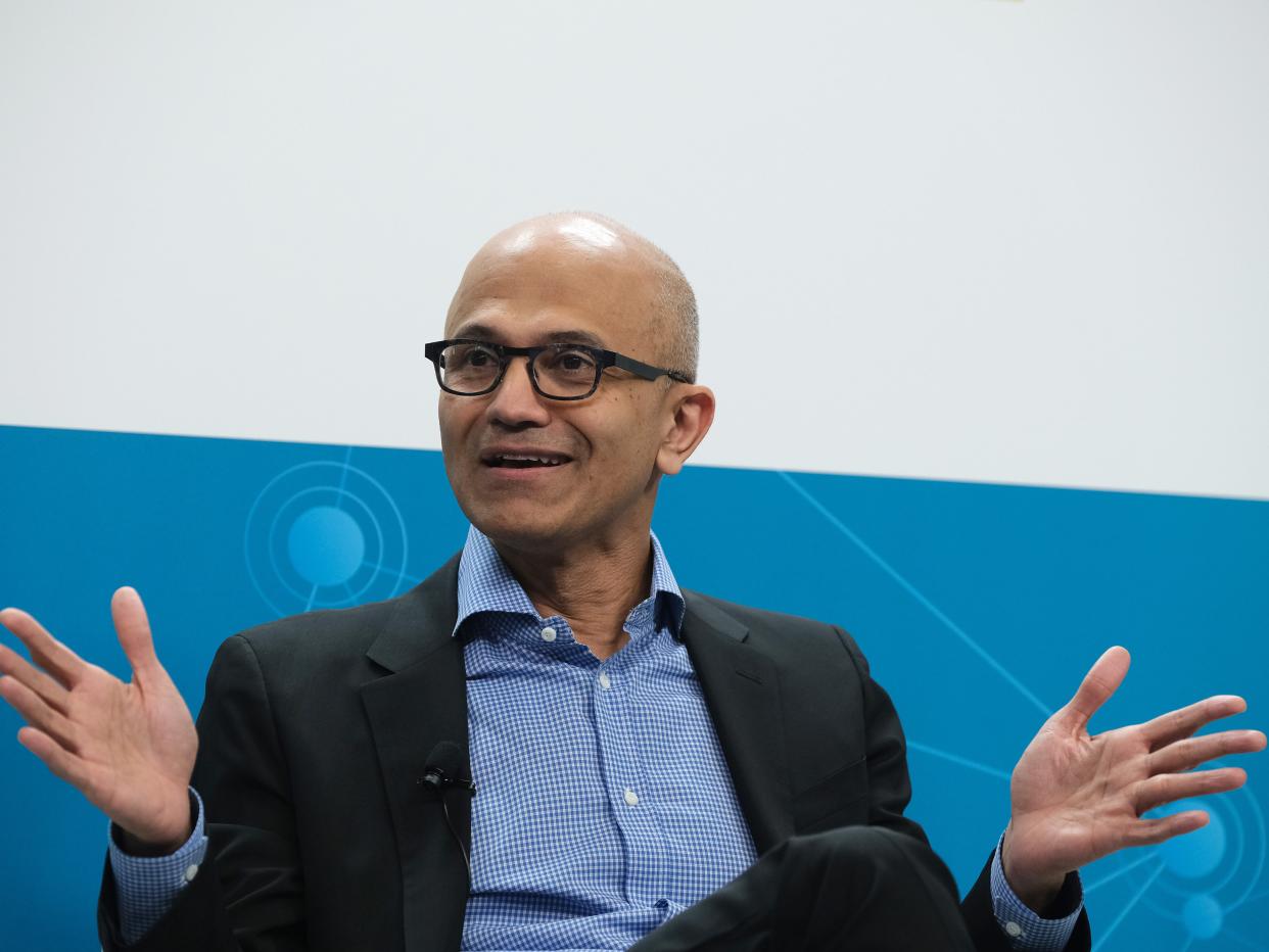 Microsoft CEO Satya Nadella, seated with open hands.