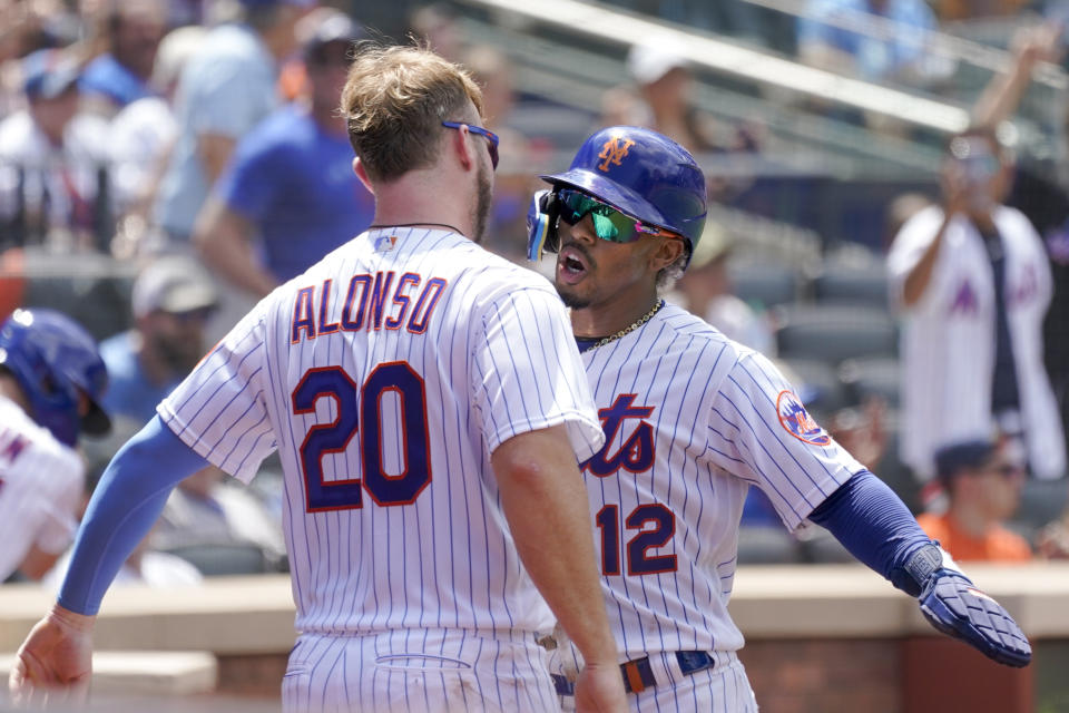 New York Mets' Francisco Lindor (12) and Pete Alonso celebrate after Lindor scored off an an RBI-double by Jeff McNeil in the third inning of game one of a double header baseball game against the Atlanta Braves, Saturday, Aug. 6, 2022, in New York. (AP Photo/Mary Altaffer)