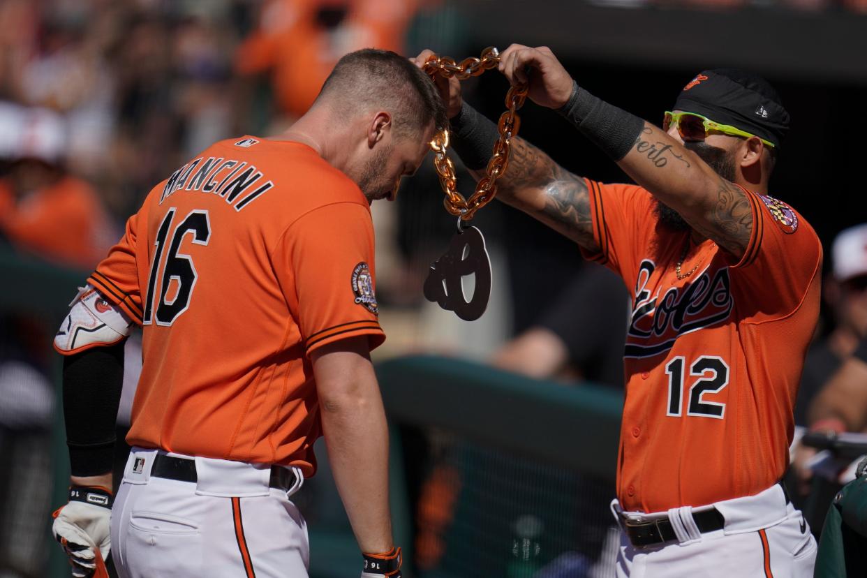 Baltimore Orioles' Rougned Odor, right, places a necklace on Trey Mancini after Mancini hit a solo home run in the first inning of a 5-4 win over the Guardians on Saturday. [Julio Cortez/Associated Press]
