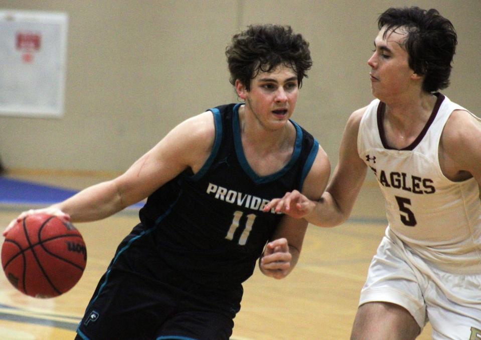 Providence forward David Fonville (11) dribbles as Episcopal forward Declan McCarthy (5) defends during the Fortegra High School 9:12 Invitational boys basketball final.