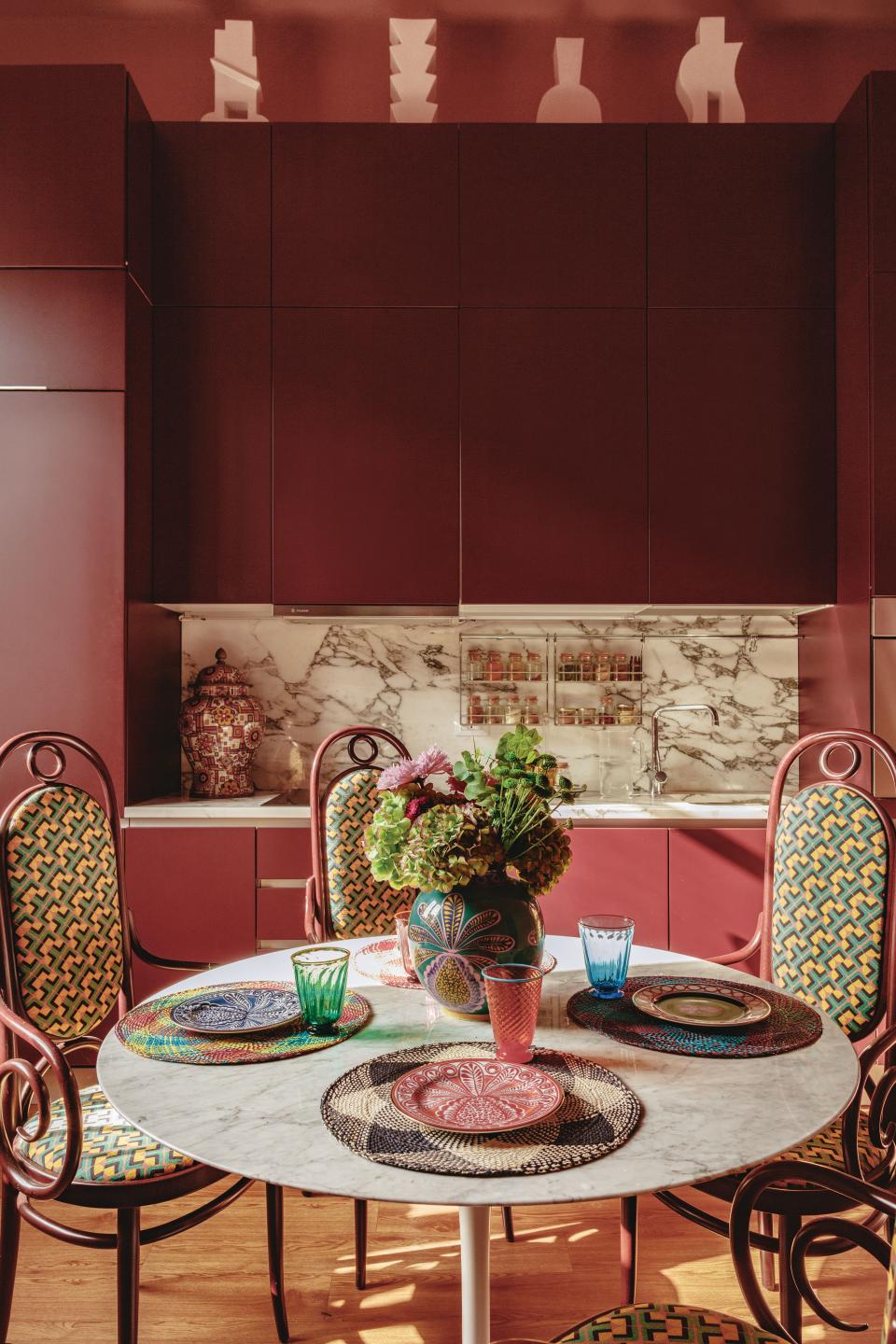 The kitchen features recycled 1990s Poliform cabinetry. Vintage Thonet dining chairs in a La DoubleJ print; custom Carrara marble-topped table.