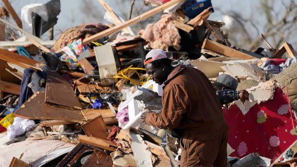 PHOTO: A resident looks through the piles of debris, insulation, and home furnishings to see if anything is salvageable at a mobile home park in Rolling Fork, Miss., Saturday, Mar. 25, 2023. (Rogelio V. Solis/AP)