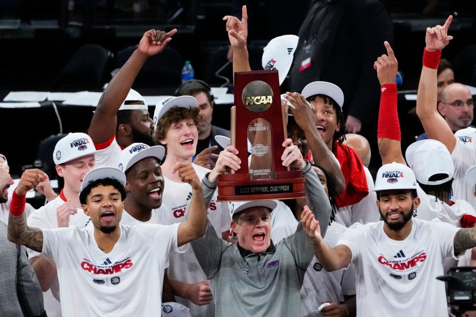 Florida Atlantic Owls head coach Dusty May hoists the East Regional Champion trophy following their 79-76 victory against the Kansas State Wildcats in an NCAA tournament East Regional final at Madison Square Garden.