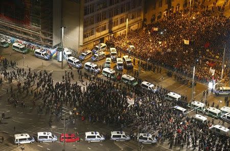 Members of LEGIDA, the Leipzig arm of the anti-immigrant movement Patriotic Europeans Against the Islamisation of the West (PEGIDA) march past anti-LEGIDA protestors (top R) during a demonstration in Leipzig January 21, 2015. REUTERS/Hannibal Hanschke