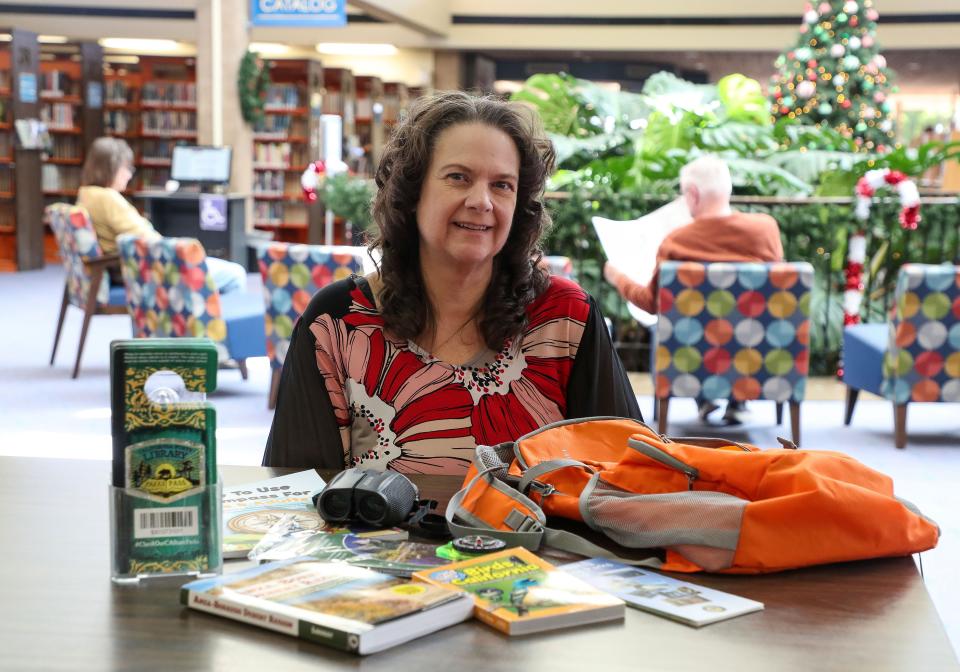 Julie Warren of the Palm Springs Public Library shows what is in a backpack that can be checked out, including books about state parks, binoculars, a compass and park passes in Palm Springs, Calif., Dec. 13, 2023. A popular program that allows patrons to check out passes for free day use parking at state parks is not included in Gov. Gavin Newsom's budget for next year.
