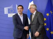 Prime Minister of Greece Alexis Tsipras (L) shakes hands with European Commission President Jean-Claude Juncker in Brussels, on June 3, 2015