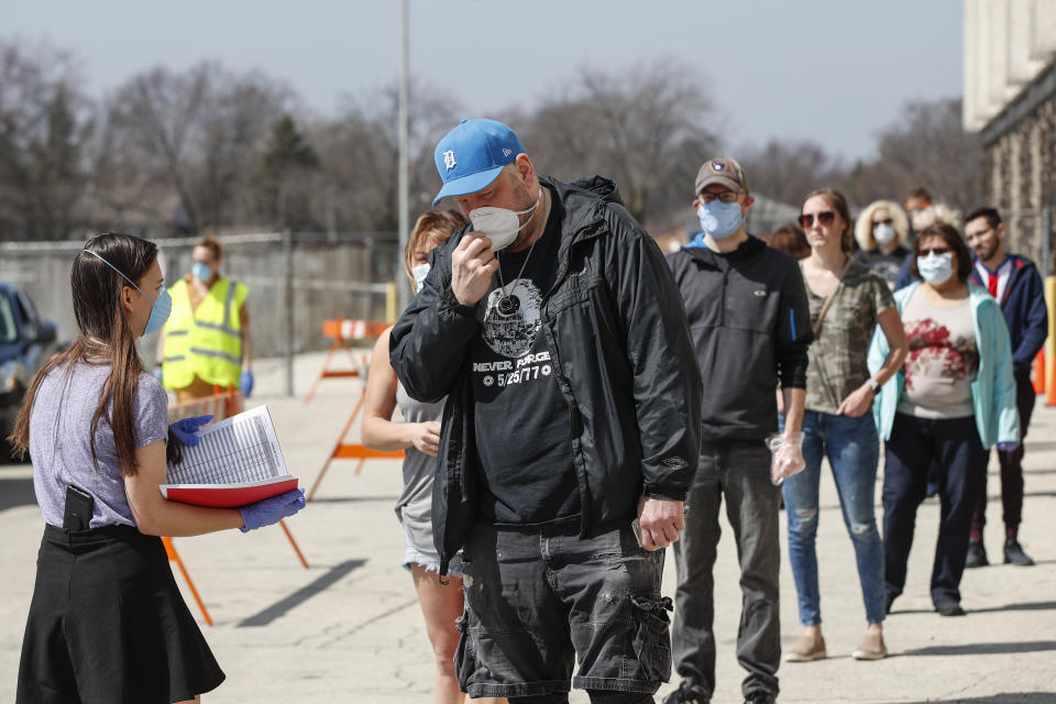 People wait in line to vote in a Democratic presidential primary election outside the Hamilton High School in Milwaukee, Wisconsin, on April 7, 2020. - Americans in Wisconsin began casting ballots Tuesday in a controversial presidential primary held despite a state-wide stay-at-home order and concern that the election could expose thousands of voters and poll workers to the coronavirus. Democratic officials had sought to postpone the election but were overruled by the top state court, and the US Supreme Court stepped in to bar an extension of voting by mail that would have allowed more people to cast ballots without going to polling stations. Both courts have conservative majorities. (Photo by KAMIL KRZACZYNSKI / AFP) (Photo by KAMIL KRZACZYNSKI/AFP via Getty Images)