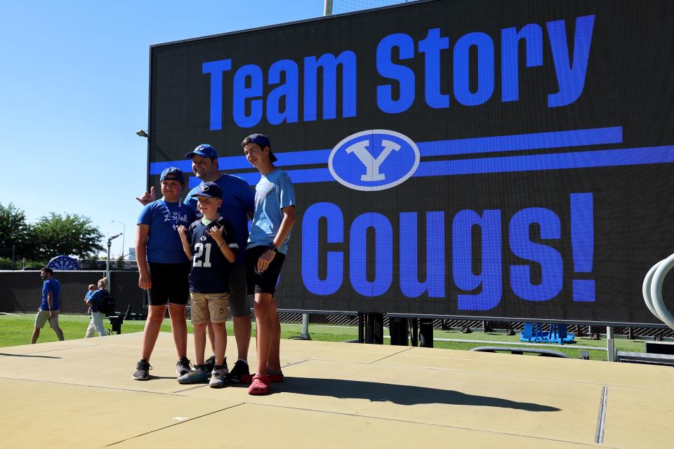 Nate Story and his kids Julia, James and Titus pose for a photo in front of a giant screen as they attend a celebration of BYU’s move into the Big 12 Conference with music, games and sports exhibits in Provo on Saturday, July 1, 2023. | Scott G Winterton, Deseret News