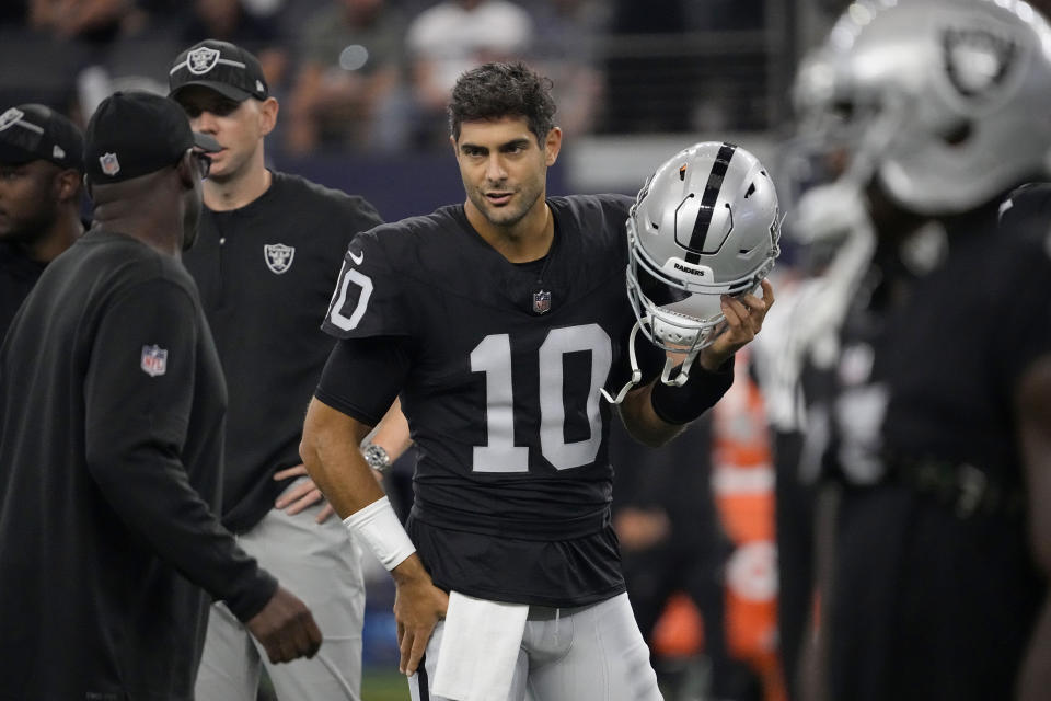 Las Vegas Raiders quarterback Jimmy Garoppolo (10) talks with staff on the field before th team's preseason NFL football game against the Dallas Cowboys in Arlington, Texas, Saturday, Aug. 26, 2023. (AP Photo/Sam Hodde)