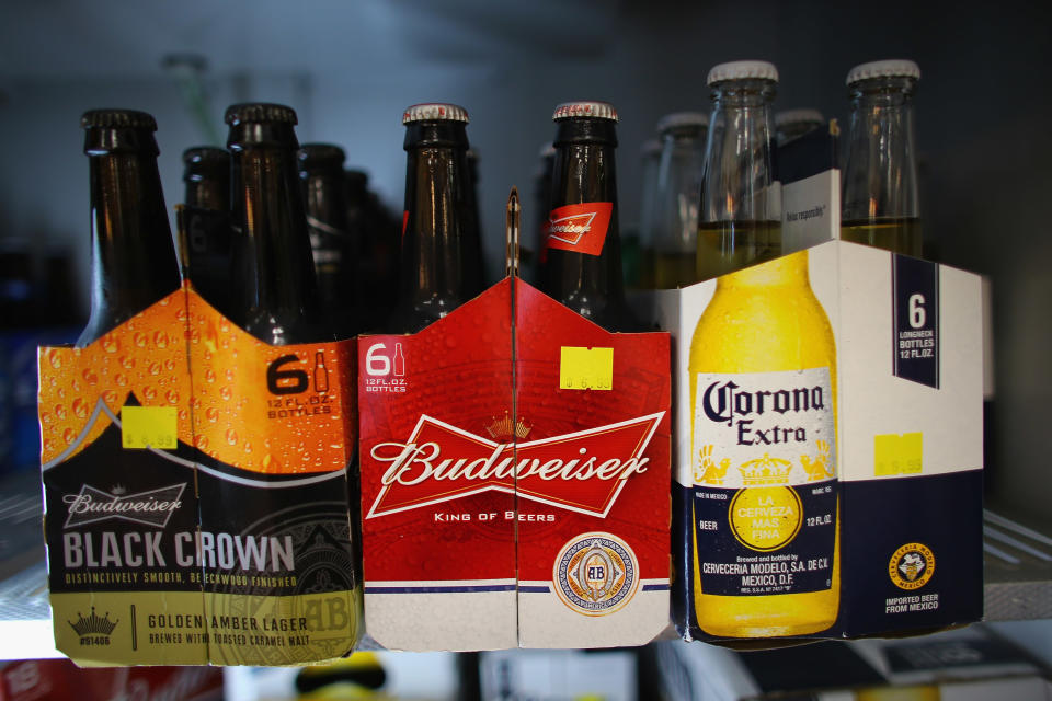 MIAMI, FL - JANUARY 31:  Six packs of Anheuser-Busch's Budweiser and Grupo Modelo's Corona Extra beers sit on a shelf at the Chandi Wine and spirits store on January 31, 2013 in Miami, Florida. Federal authorities filed a lawsuit January 31, to stop the Anheuser-Busch InBev's $20.1 billion takeover of Grupo Modelo.  (Photo  by Joe Raedle/Getty Images)