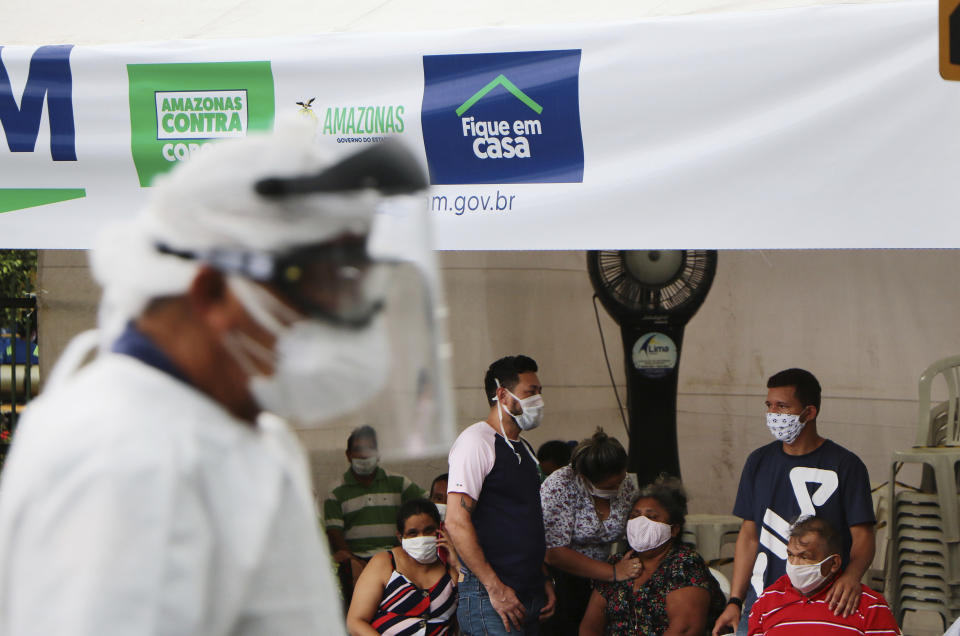 In this April 16, 2020 photo, people suspected of suffering from COVID-19 disease, wait for medical attention outside the 28 de Agosto hospital in Manaus, Amazonas state, Brazil. The city has one of the highest rates of new coronavirus infection in Brazil, though experts say the total greatly under-represents the true number of infections. (AP Photo/Edmar Barros)