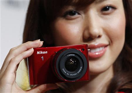 A model poses with Nikon Corp's new Nikon 1 J1 camera at its unveiling ceremony in Tokyo, in this September 21, 2011 file photo. REUTERS/Kim Kyung-Hoon/Files