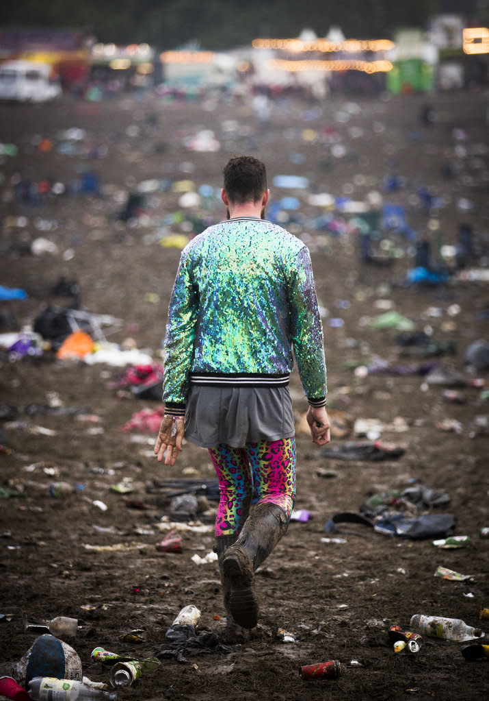 A music fan clad in wellies makes his way out of the festival.