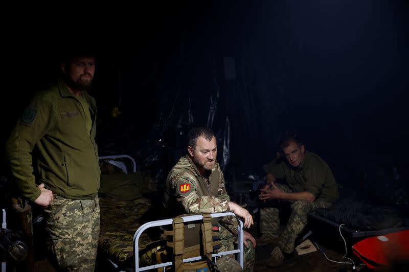 Ukrainian servicemen wait for a combat work inside a dugout at a position near a border in Kharkiv region