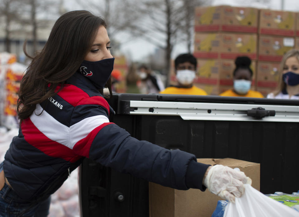 Texans' Hannah McNair distribute supplies during the Neighborhood Super Site food distribution event organized by the Houston Food Bank and HISD, Sunday, Feb. 21, 2021, in Houston. (Marie D. De Jesús/Houston Chronicle via AP)