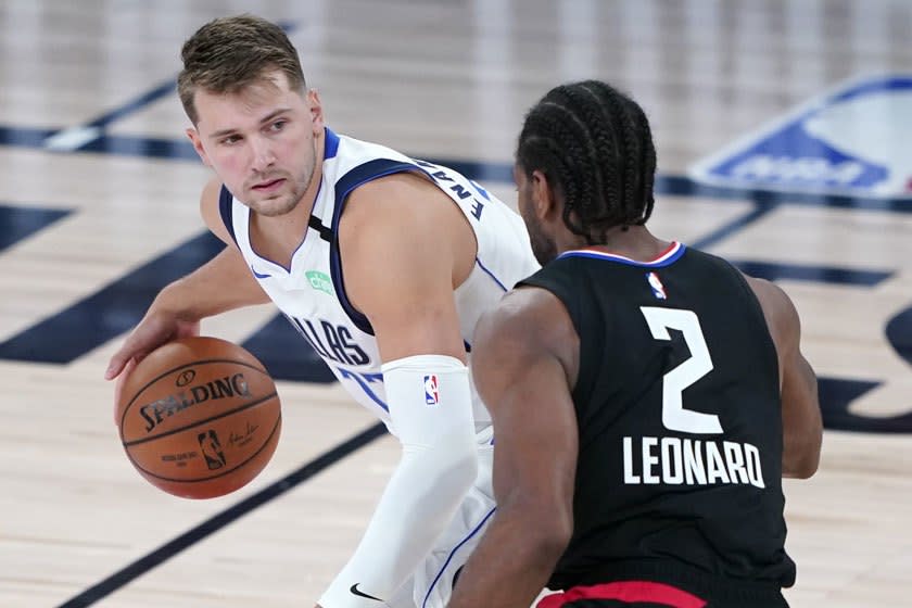 Dallas Mavericks guard Luka Doncic controls the ball in front of Clippers forward Kawhi Leonard.