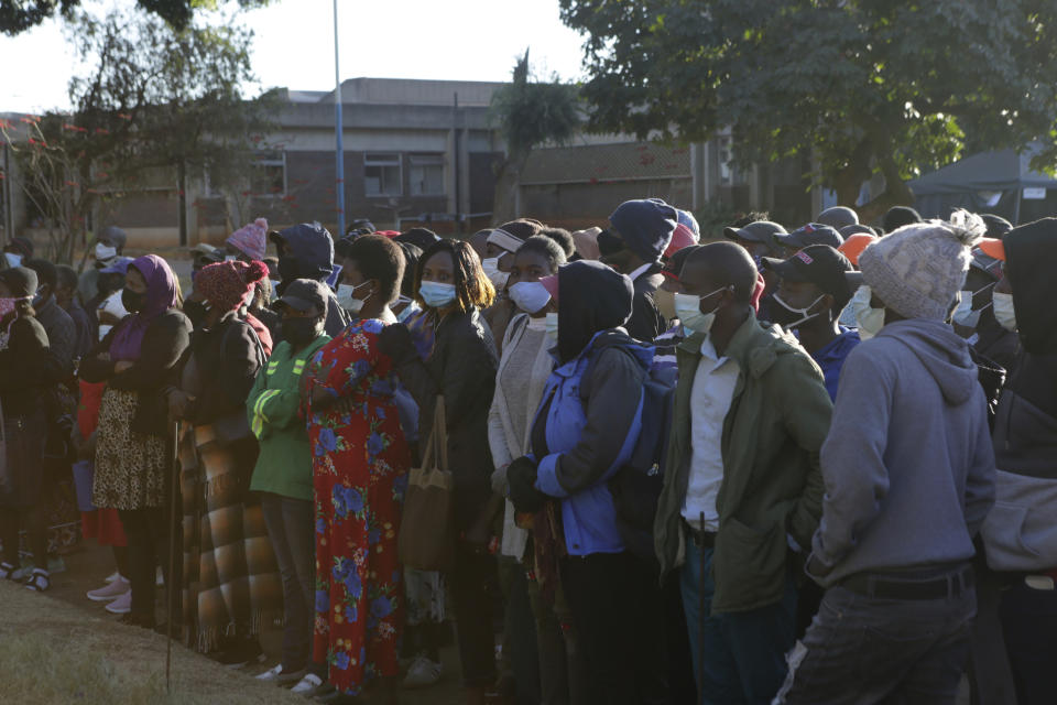 People wait in a queue to be vaccinated at a government hospital in Harare, Zimbabwe on Friday, Sept, 17, 2021. Many employers in Zimbabwe are mandating COVID-19 vaccines for their staff, and the government has its own requirement that its 500,000 employees get the shots. That sets the southern African nation apart from nearly every other on the continent, where the most immediate challenge is still simply acquiring enough doses. (AP Photo/Tsvangirayi Mukwazhi)