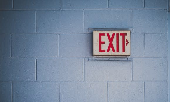 An exit sign on a concrete wall.