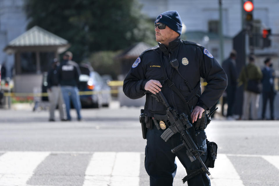 Un agente de la Policía del Capitolio armado con un fusil vigila el lugar donde un vehículo embistió una barrera en el Capitolio en Washington, el viernes 2 de abril de 20021. (AP Foto/Jacquelyn Martin)